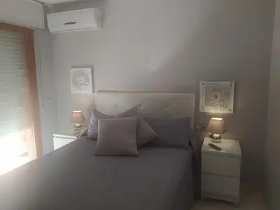 a bedroom with a large bed with two lamps at Áprtamento novo Santi Petri in Chiclana de la Frontera