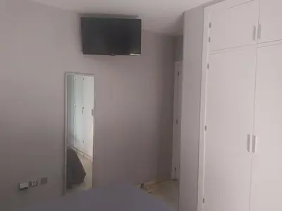 a white room with a television on the wall at Áprtamento novo Santi Petri in Chiclana de la Frontera