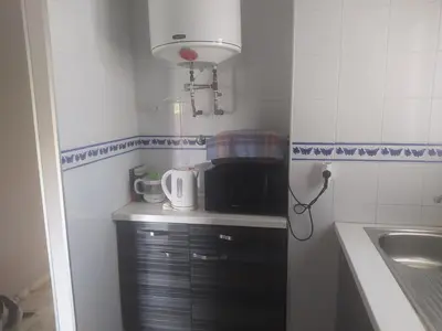 a small kitchen with a sink and a microwave at Áprtamento novo Santi Petri in Chiclana de la Frontera