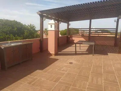 a patio with a roof with a bird house on it at Áprtamento novo Santi Petri in Chiclana de la Frontera