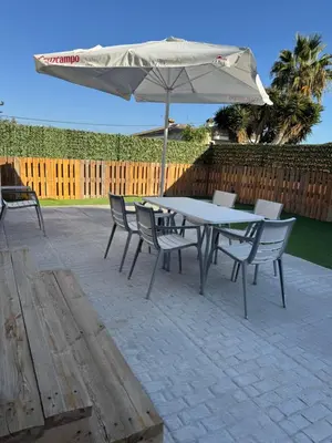 a table and chairs with an umbrella on a patio at Mobil Home La Barrosa in Chiclana de la Frontera