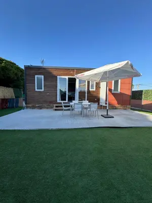 a patio with a table and a white umbrella at Mobil Home La Barrosa in Chiclana de la Frontera
