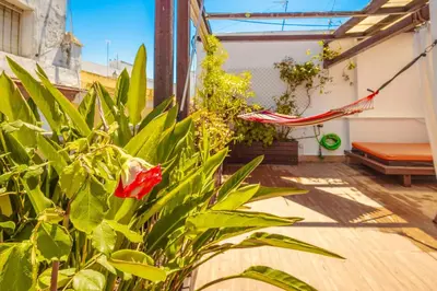 a patio with a red hammock and a plant at Cadizz-Ático El Falla con terraza de 40m2 in Cádiz