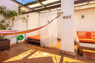 a hammock in a room with a couch at Cadizz-Ático El Falla con terraza de 40m2 in Cádiz