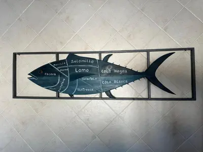 a fish sign on a glass shelf on a wall at El Levante in Chiclana de la Frontera