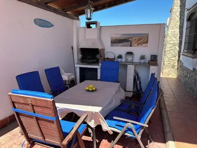 a table and chairs in a kitchen with a stove at El Levante in Chiclana de la Frontera