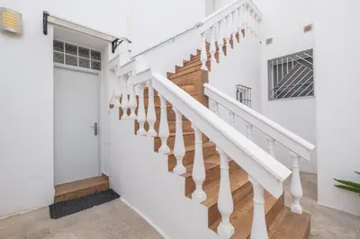 a staircase in a home with white walls and wood floors at Geminis in Rota