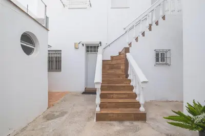 a staircase in a building with white walls and wooden floors at Geminis in Rota