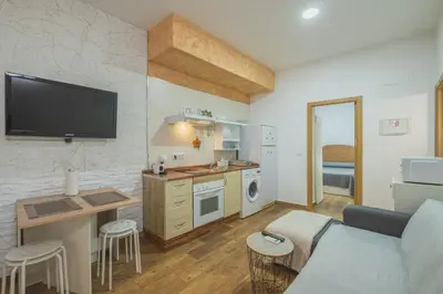 a living room with a couch and a kitchen at Geminis in Rota