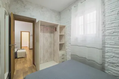 a bedroom with a walk in closet and a window at Geminis in Rota
