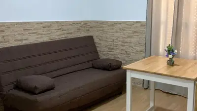 a living room with a bed and a table and a tv at Apartamento Caleta Beach in Cádiz