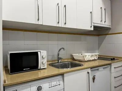 a kitchen with a sink and a microwave at Loft El Capricho Grupo Ac Gestion in Cádiz