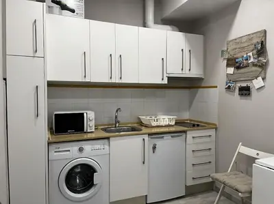 a kitchen with a washing machine and a microwave at Loft El Capricho Grupo Ac Gestion in Cádiz