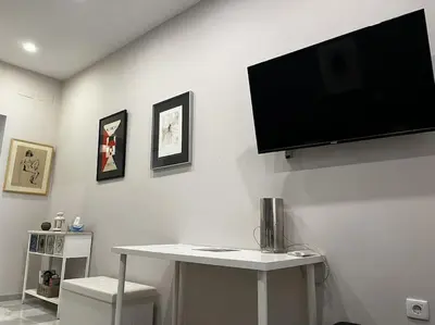 a room with a table and a tv on the wall at Loft El Capricho Grupo Ac Gestion in Cádiz