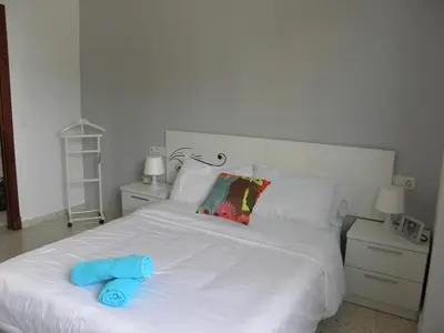 a white bed with a blue towel on it at Apartamento en Jerez de la Frontera in Jerez de la Frontera