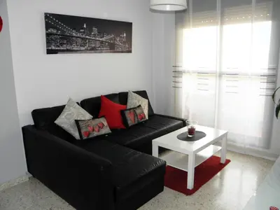 a living room with a black couch and a white table at Apartamento en Jerez de la Frontera in Jerez de la Frontera