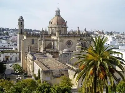 a large building with a palm tree in front of it at Apartamento en Jerez de la Frontera in Jerez de la Frontera