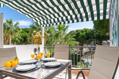 a table with glasses of orange juice on a patio at Penthouse Sol y Mar in Poblado de Sancti Petri