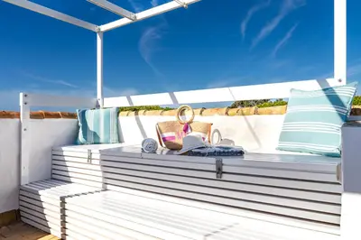 a bench on the deck of a boat at Penthouse Sol y Mar in Poblado de Sancti Petri
