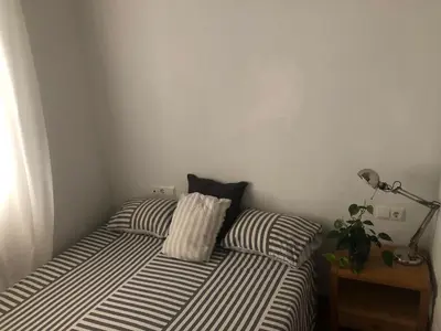 a bedroom with two beds with striped pillows and a lamp at Apartamento San Bartolomé in El Puerto de Santa María