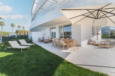 a patio with a table and chairs and an umbrella at Oasis playa costa Ballena in Costa Ballena