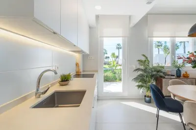 a kitchen with a sink and a table and chairs at Oasis playa costa Ballena in Costa Ballena