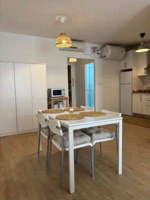 a white table and chairs in a room at Apartamentos Banda Playa in Sanlúcar de Barrameda