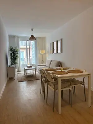 a living room with a table and a couch at Apartamentos Banda Playa in Sanlúcar de Barrameda