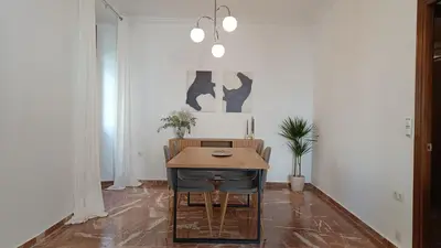 a living room with a table with a tv and flowers at Sherryflat Torán in Jerez de la Frontera