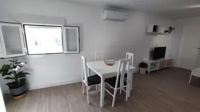 a white room with a table and chairs and a television at El mirador de Beatriz in Arcos de la Frontera