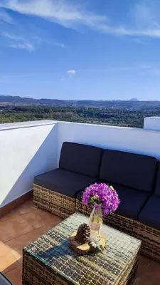 a vase of flowers on a table on a balcony at El mirador de Beatriz in Arcos de la Frontera
