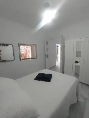 a white bedroom with a bed and a light on the ceiling at Casa Encarnita in Arcos de la Frontera