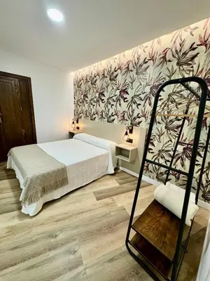 a bedroom with a bed and a wall with flowers at Solera Suites in Jerez de la Frontera