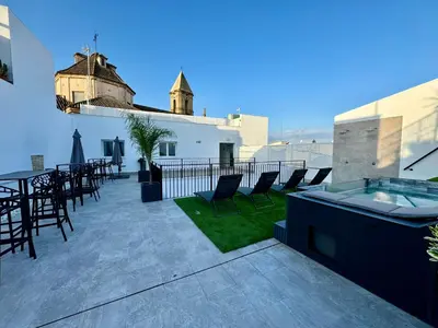 a patio with chairs and a hot tub on a building at Solera Suites in Jerez de la Frontera
