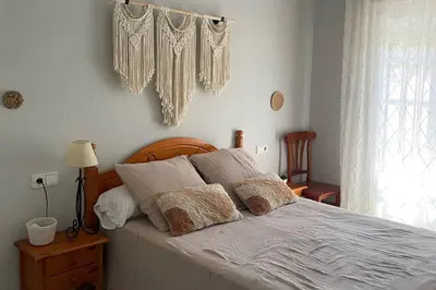 a bedroom with a bed with white sheets and pillows at Apartamento La Barrosa Beach in Novo Sancti Petri