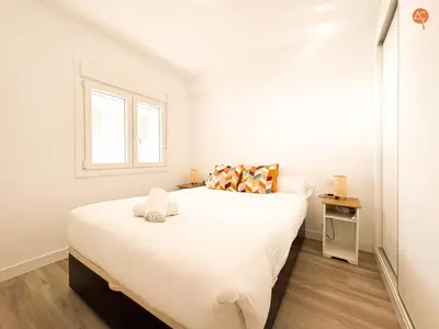 a bedroom with a large white bed with a window at La Palmera Grupo AC Gestion in Cádiz