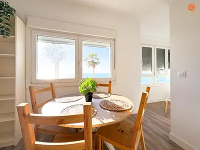 a dining room with a table and chairs and a window at La Palmera Grupo AC Gestion in Cádiz