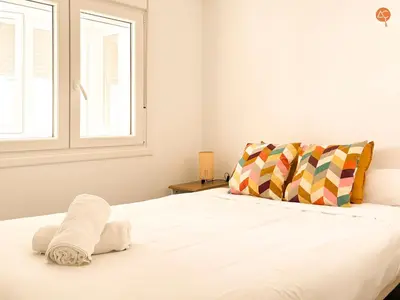 a bedroom with a white bed with a window at La Palmera Grupo AC Gestion in Cádiz