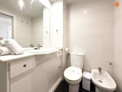 a white bathroom with a toilet and a sink at La Palmera Grupo AC Gestion in Cádiz