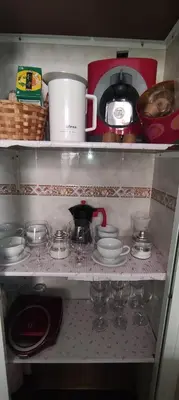 a kitchen shelf with dishes and a coffee maker at Vivir es Increíble in San Fernando