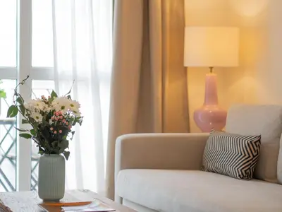 a living room with a couch and a vase of flowers on a table at Apartamento Centro&Playa Sanlucar - V Centenario in Sanlúcar de Barrameda