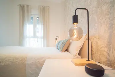 a bedroom with a bed and a lamp on a table at Apartamento Centro&Playa Sanlucar - V Centenario in Sanlúcar de Barrameda