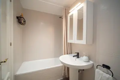 a white bathroom with a sink and a bath tub at Apartamento Centro&Playa Sanlucar - V Centenario in Sanlúcar de Barrameda