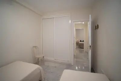 a white room with a bed and a sliding door at Apartamento Centro Sanlucar - Banda Playa in Sanlúcar de Barrameda