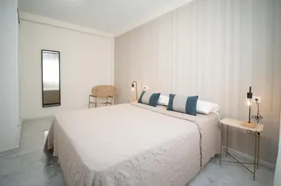 a bedroom with a large bed with blue and white pillows at Apartamento Centro Sanlucar - Banda Playa in Sanlúcar de Barrameda