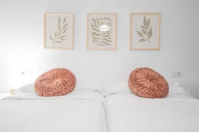 two ombre pillows sitting on top of a white couch at Soto Urban Apartment in Cádiz