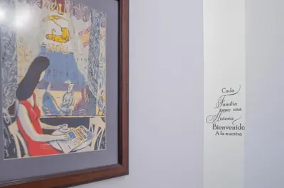a framed painting of a woman reading a newspaper at Soto Urban Apartment in Cádiz