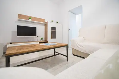 a living room with a table with a tv and a couch at Soto Urban Apartment in Cádiz