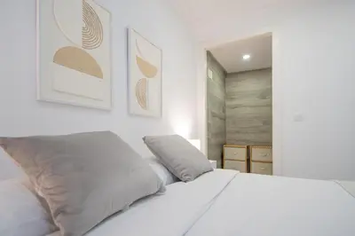 a white bed with two pillows on top of it at Soto Urban Apartment in Cádiz