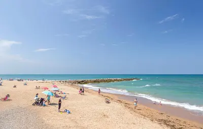 a group of people on a beach near the ocean at Nice Apartment In Chipiona With Wifi in Chipiona